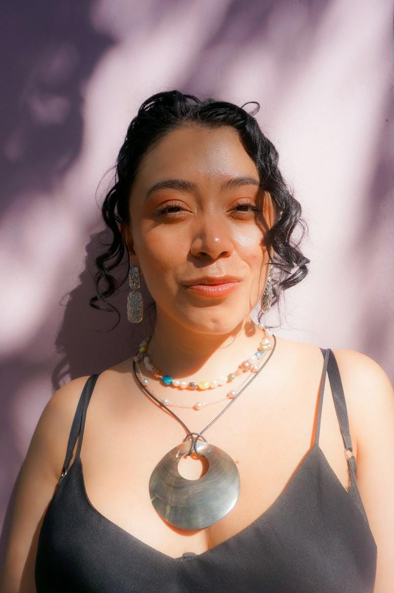 A model wearing layered artisanal necklaces and bracelets, styled with casual chic attire for an everyday look.