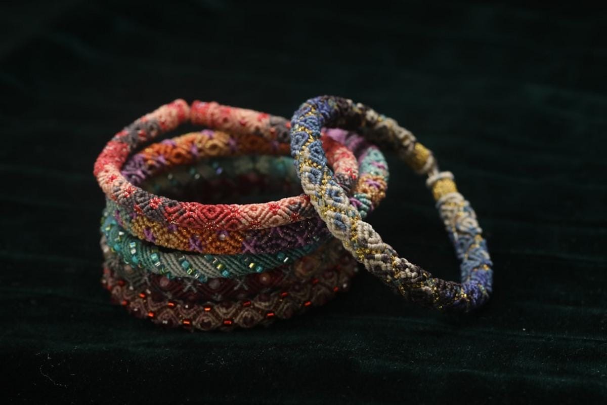 handmade jewelry An artisan workshop showcasing handcrafted jewelry with vibrant threads and intricate metalwork, highlighting the artisanal process behind high-quality accessories.