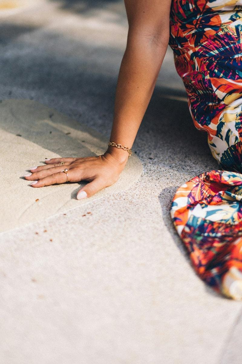 Close-up of a woman wearing layered artisanal necklaces and textured bracelets, with natural lighting highlighting the craftsmanship