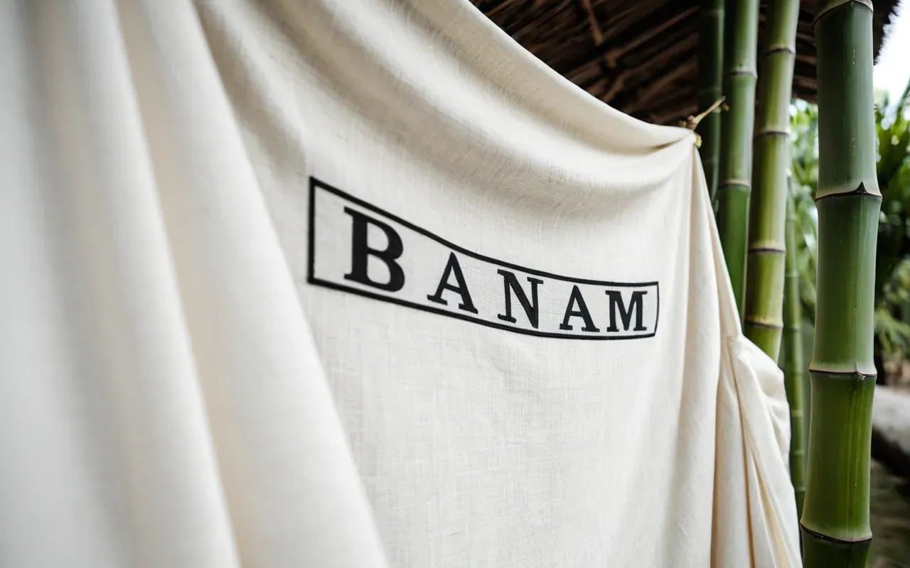 bamboo fabric texture A soft-focus, close-up photograph of high-quality, breathable bamboo fabric draped elegantly on a clean, minimalist white surface, highlighting its texture and natural fibers under soft, diffused lighting.
